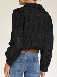 Detail of black puff sleeve cardigan with intricate eyelet embroidery on back side