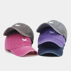 Détail de quatre casquettes de baseball rétro en coton lavé avec motif de chien brodé