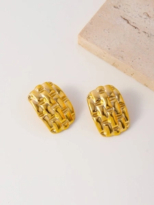 Detail of minimalist rectangular gold earrings with woven texture on beige stone