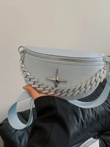 Detail of light blue pebble leather chest bag featuring silver star and rhinestone chain