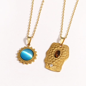Detail of vintage 14K gold-plated titanium steel necklaces with sun and oval gemstones