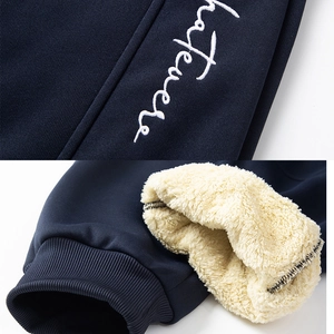 Detail of navy fleece joggers showing Whatever embroidery and thick lamb wool lining