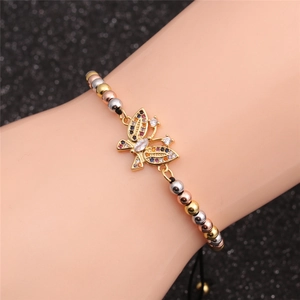 Close-up of zircon butterfly bracelet featuring tri-color gold beads on a wrist