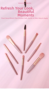 Detailed view of 8 soft synthetic fiber makeup brushes arranged on pink silk fabric