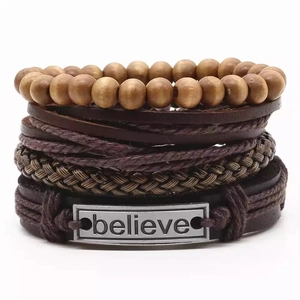 Détail macro de bracelets en cuir multicouches avec perles en bois et plaque believe