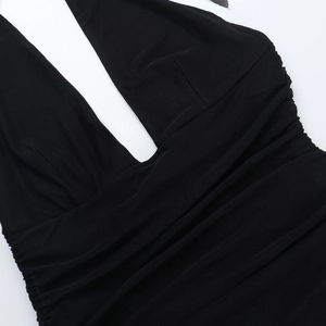 Detail of black deep V-neck halter dress with side ruching and fine mesh fabric texture