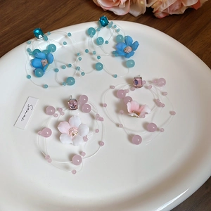 Detailed view of floral beaded long tassel earrings with blue and pink fabric petals