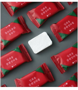 Macro view of soft white disposable face towel surrounded by red and green packaging