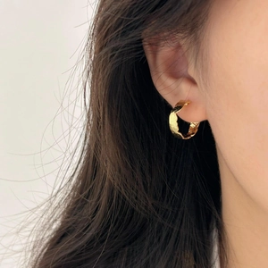 Close-up of model wearing gold hammered texture hoop earrings in 925 sterling silver