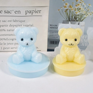 Detailed view of handmade matte geometric bear candle molds in light blue and yellow