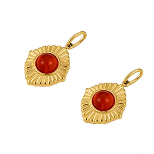 Detailed view of vintage gold sunburst pendants with inlaid round red natural stones