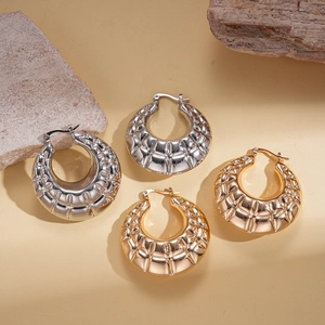 Textured geometric gold and silver hoop earrings with vintage relief pattern
