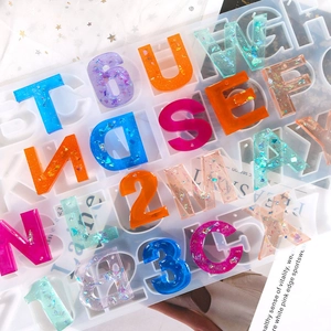 Macro view of silicone mold with finished glitter resin alphabet and number charms