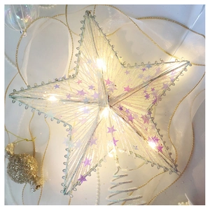 Detail of warm white LED Christmas tree topper star with purple sequins and wire craft