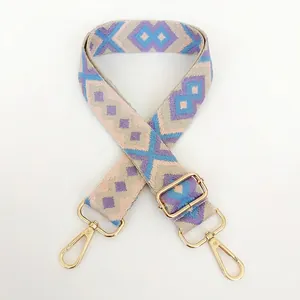 Detail view of purple geometric jacquard woven bag strap with adjustable gold buckle