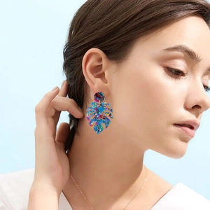 Acrylic leaf earrings with sequins on model showing size and iridescent colorful effect