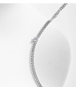 Macro shot of silver heart crystal pendant on a stylish cuban chain necklace
