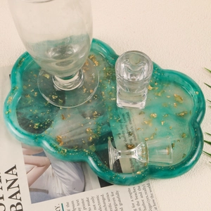 Detail of emerald green resin tray with gold foil flakes and wavy edges for jewelry