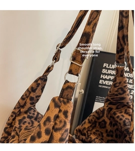 Close-up of adjustable strap with silver hardware on leopard print shoulder bag