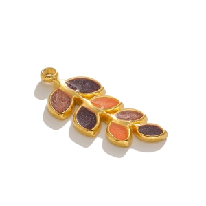 Macro shot of gold leaf pendant with deep purple and orange glitter enamel inlay