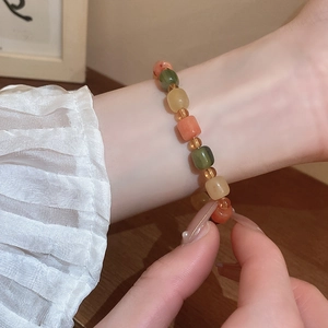 Detail view of colorful beads bracelet worn on wrist with earthy natural tones