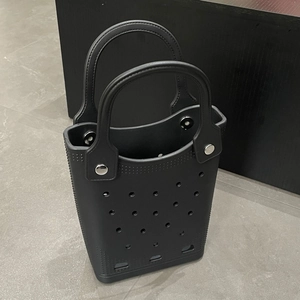 Detail of waterproof black EVA beach tote bag showing perforated design and sturdy rivets