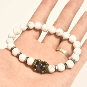 Vista macro del bracciale a corona con ametista viola e perle in marmo bianco