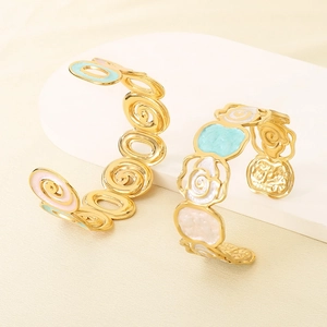 Golden spiral open bangle with colorful enamel flower design in a minimalist aesthetic