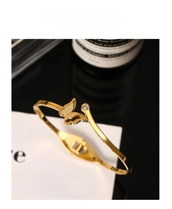 Detail of 18k gold butterfly open bangle with matte wing texture and sparkling zircon
