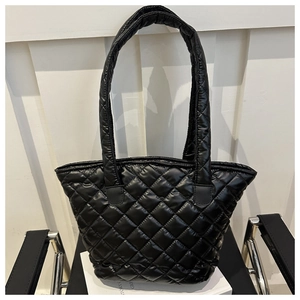 Détail du sac cabas matelassé noir montrant la texture en nylon brillant et les losanges