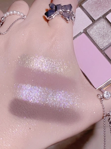 Nahaufnahme von glitzernden rosa und lila Lidschatten-Swatches auf der Haut mit matten Texturen