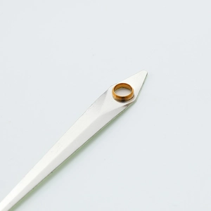 Macro view of silver metal watch hands with gold mounting holes on white background