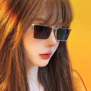 Close-up of stylish silver metal square sunglasses with dark gray lenses on a model