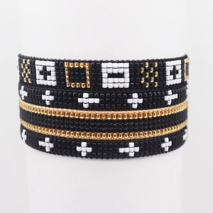 Macro shot of multi-layer Miyuki bead bracelets with geometric weaving and gold cross charm