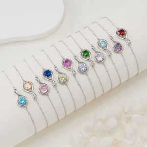 Ten 925 silver infinity bracelets with colorful gemstones on a white elegant display
