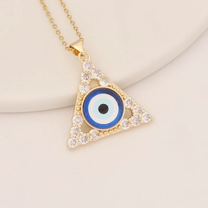 Detailaufnahme eines goldenen Dreieck-Anhängers mit zirkonbesetztem Evil-Eye-Motiv