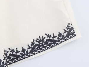 Detailed macro view of white fabric with fine black botanical prints and textile texture