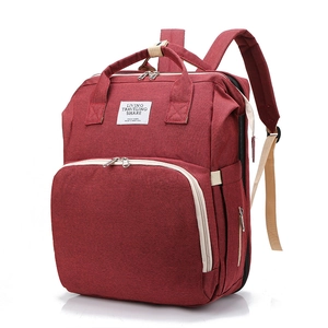 Detail view of burgundy waterproof fabric diaper bag with spacious compartments and straps
