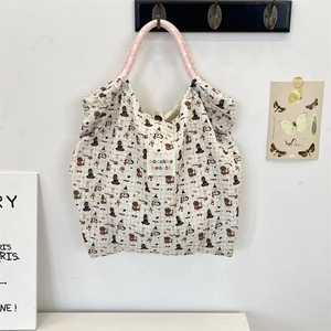 Close-up of cream canvas tote bag with cute animal prints and woven handles