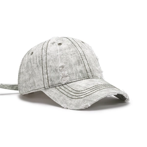 Distressed grey washed denim baseball cap with vintage frayed holes and curved brim