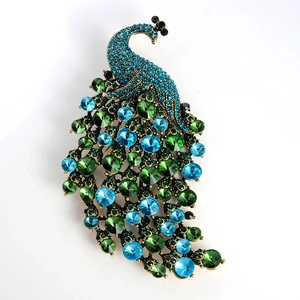 Vintage peacock brooch in bronze-tone alloy with colorful blue and green crystals