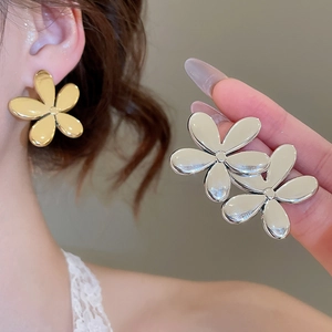 Détail de boucles d'oreilles fleurs métalliques brillantes en or et argent