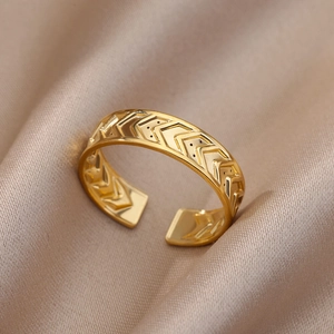 Detailed close-up of 18k gold-plated chevron patterned adjustable ring on silk fabric