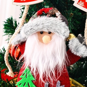 Close-up of plush Santa Claus ornament with felt body and white beard on Xmas tree
