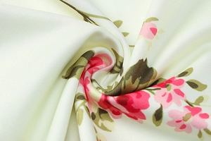 Detailed close-up of floral fabric pattern with pink flowers and green leaves on beige