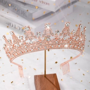 Detailed view of a rose gold bridal crown with crystals on a wooden stand