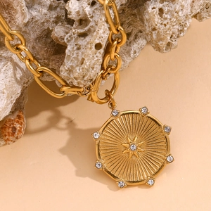 Detailed view of 18K gold plated starburst disc pendant on chunky chain with OT clasp