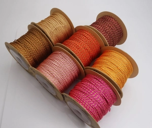 Macro shot of 1mm gold-wired cotton threads in warm colors on spools for DIY jewelry making