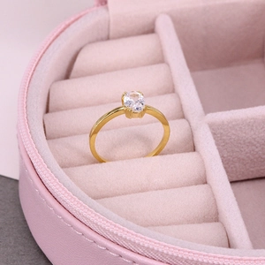 Close-up of elegant gold ring with oval crystal stone in a pink velvet jewelry box