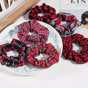 Detail view of six vintage red plaid fabric hair scrunchies with various check patterns